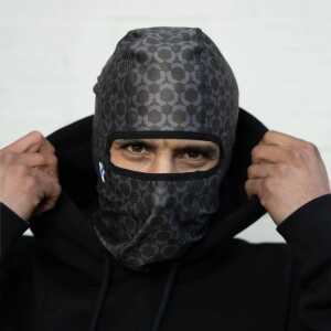 A person wearing a black balaclava with a Method star logo.