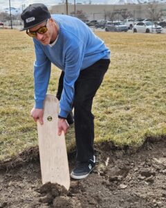 "D’Beau" Darin Black using a skateboard deck to ceremonially break ground at Optimist Skatepark, Pocatello, March 21st, 2025.